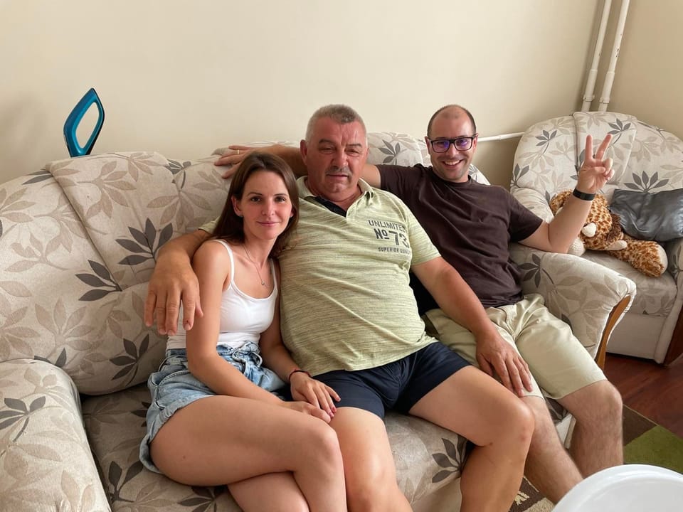 Zoli a kanapé közepén, két oldalán egy-egy mosolygós családtag